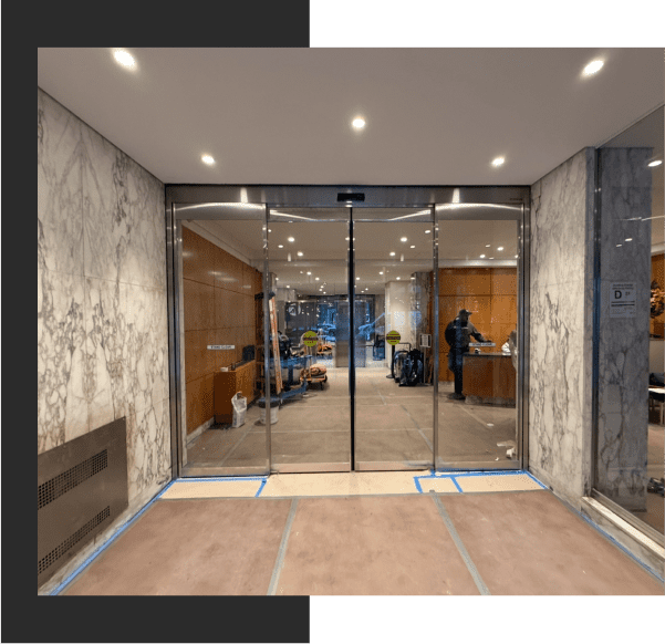 Building entrance with marble walls and glass doors.