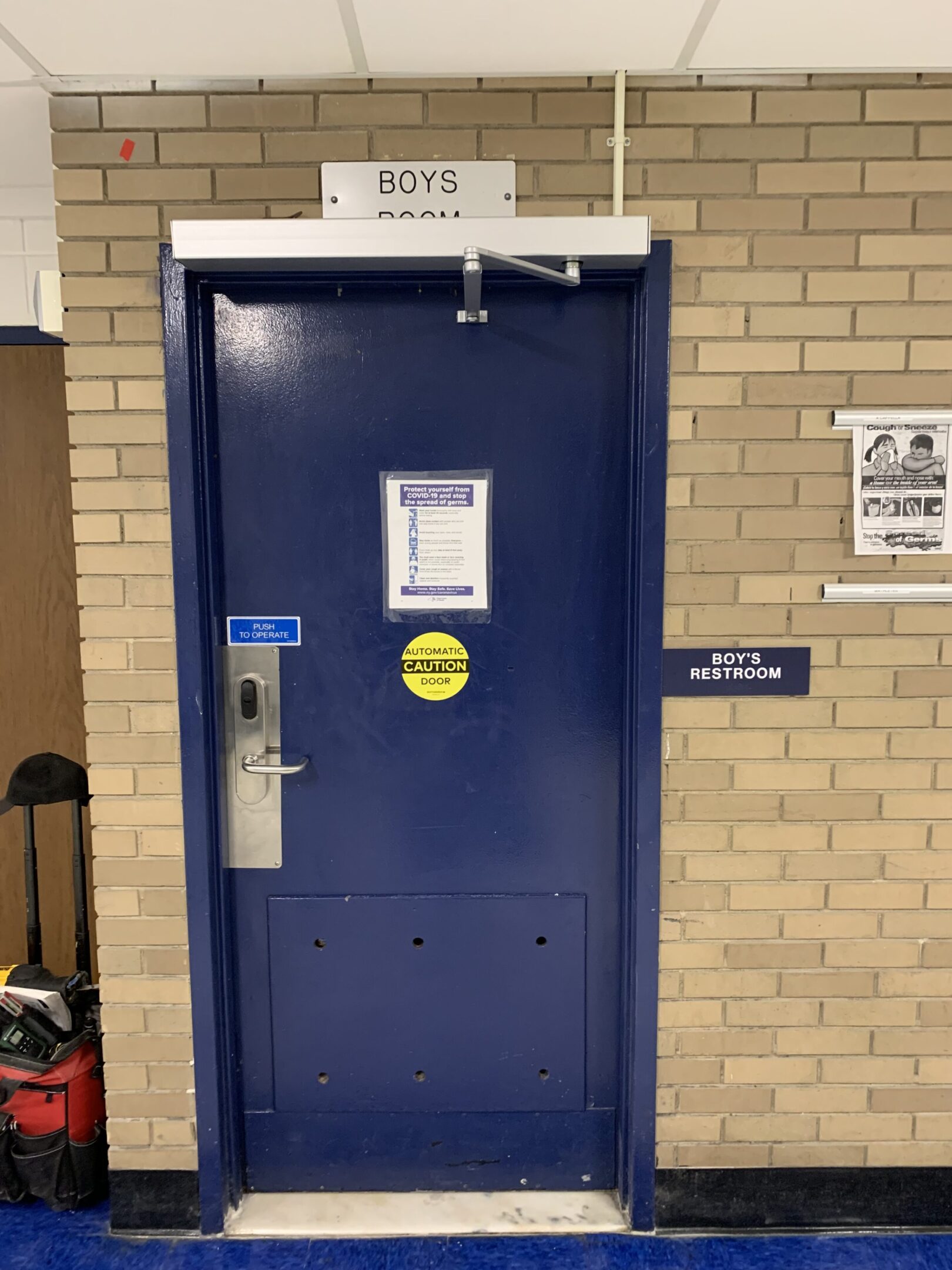 Blue door labeled "Boys Restroom" in school.