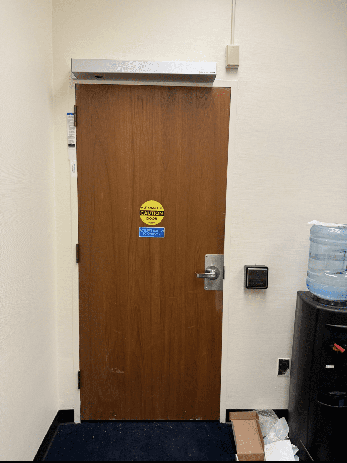 Office door with caution sign and water cooler.