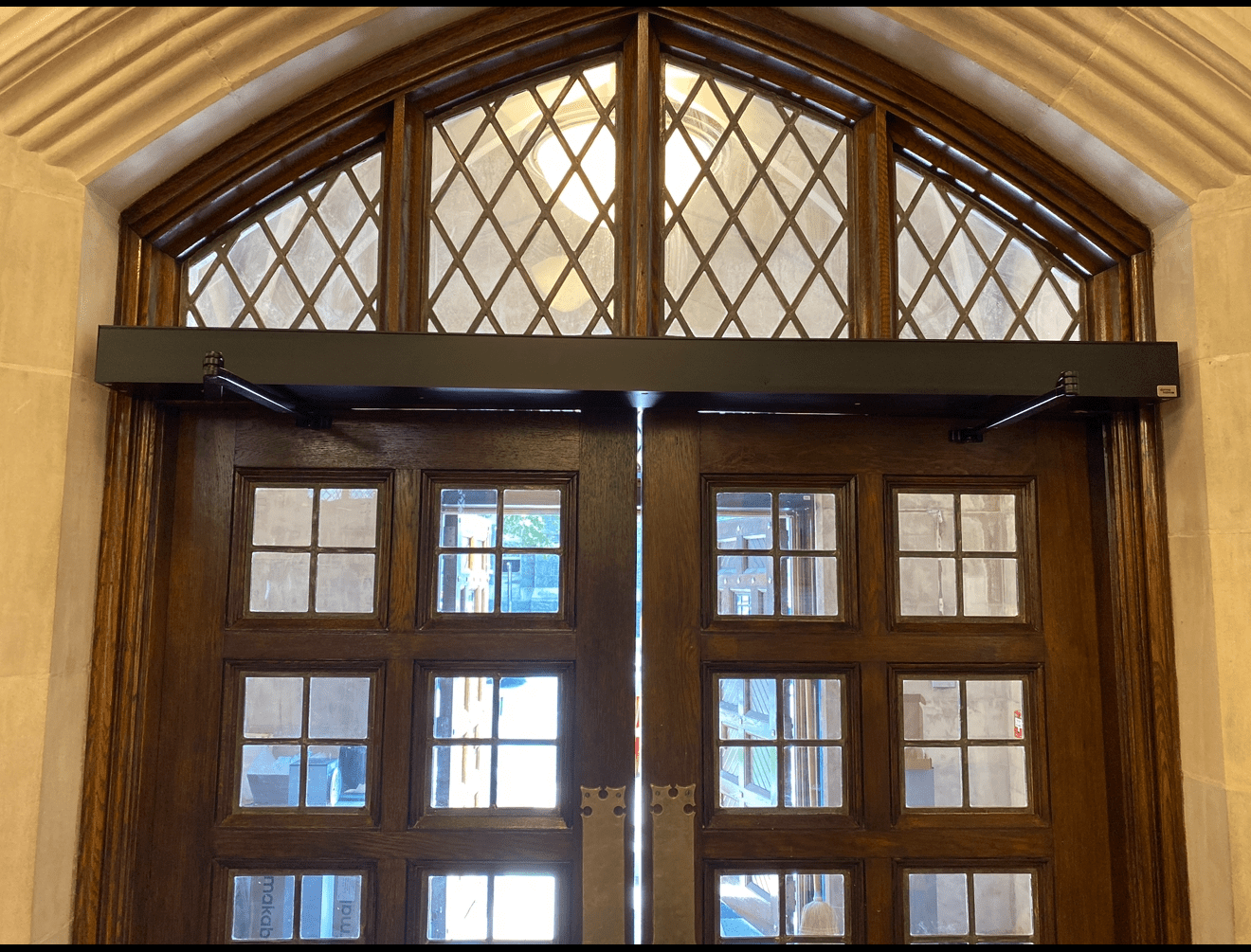 Wooden double doors with decorative glass panels.