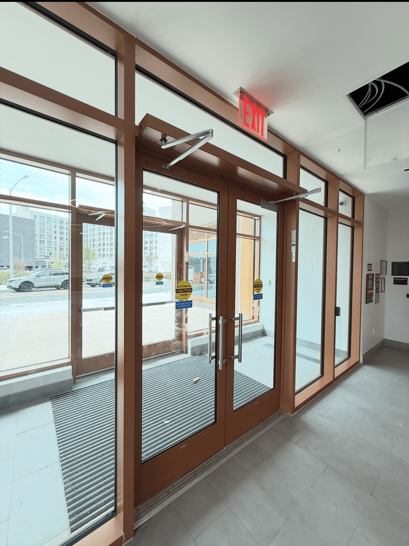 Glass entrance doors with exit sign above.
