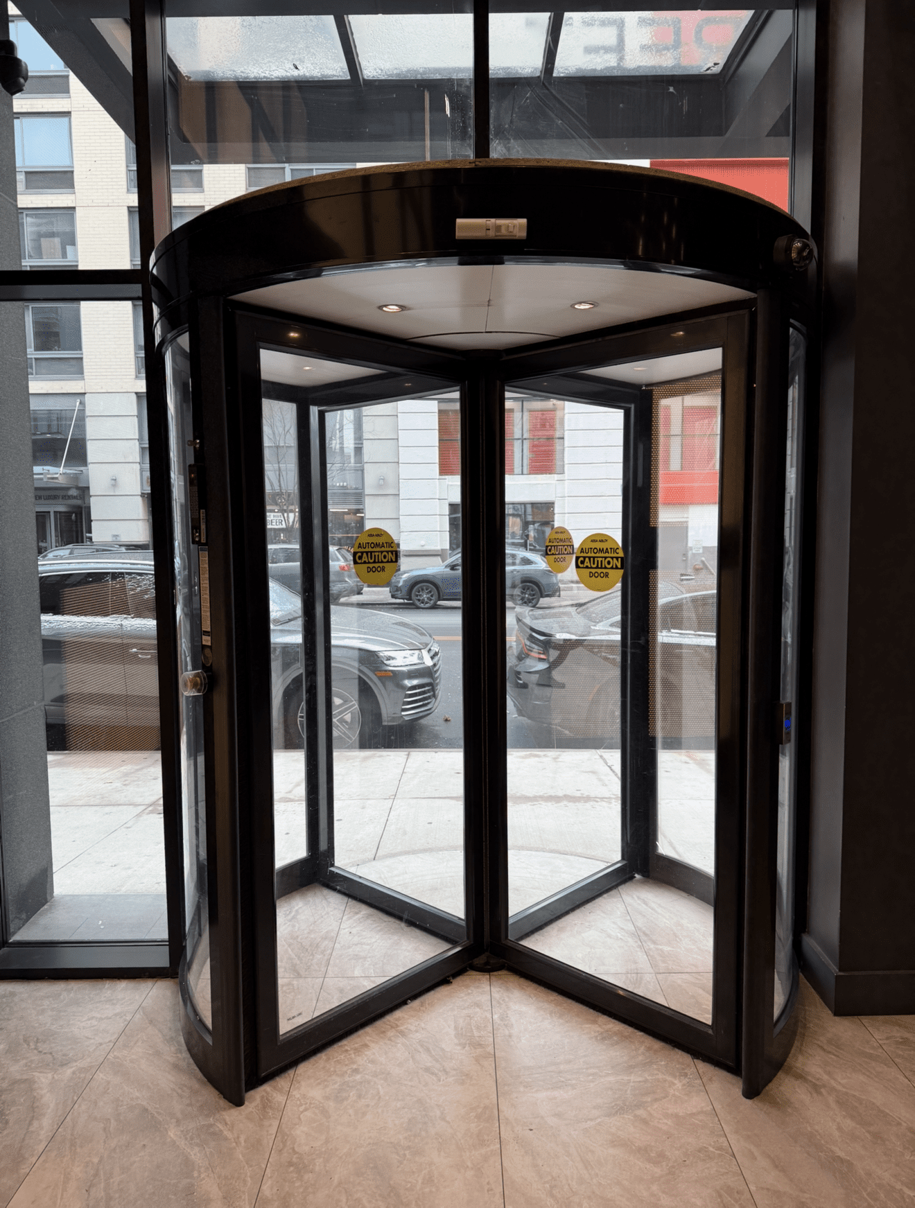 Revolving glass door in modern building entrance.